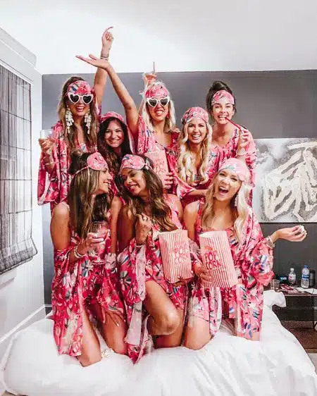 groupe de femmes habillé en rose pour un evjf sur un lit blanc célébration