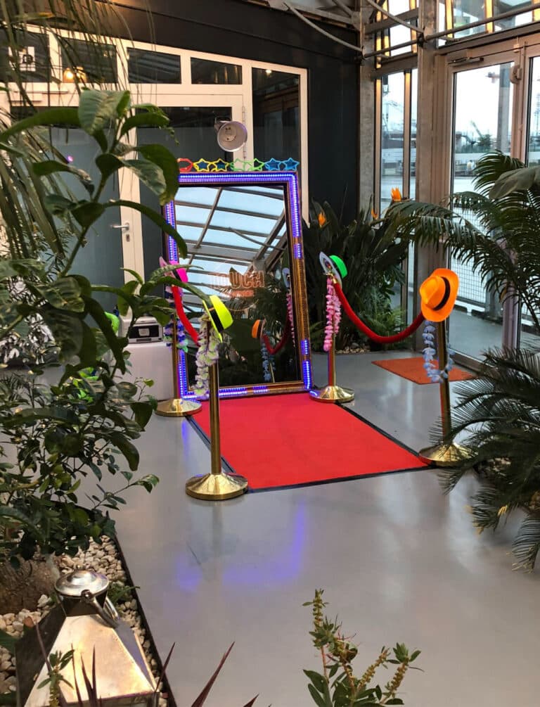 Miroir photobooth tapis rouge évènement saint-denis des chapeaux panama fluo orange jaune vert et rose. En premier plan des arbres et palmier