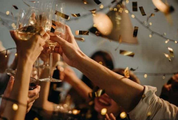 bras champagne verre en l'air main cotillon or fête anniversaire doré